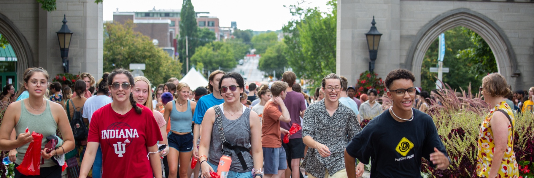 A group of students walking through the Sample Gates on IU's campus