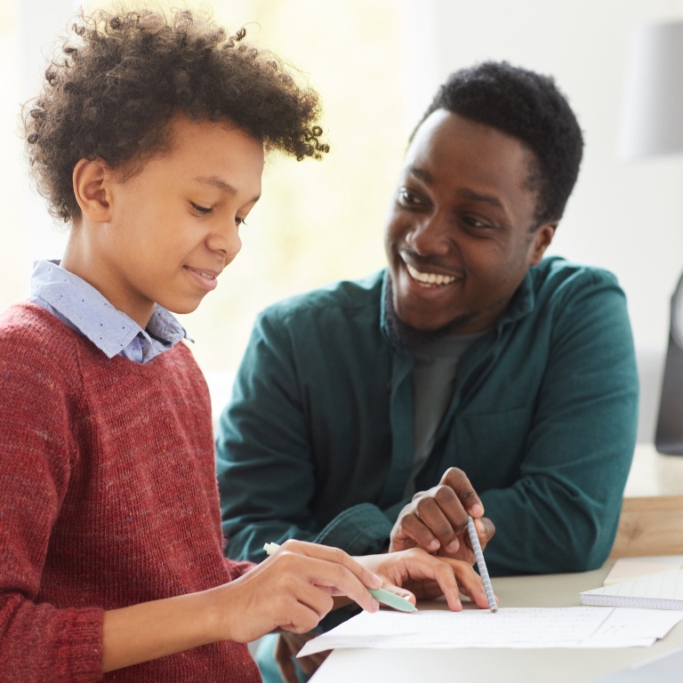 Smiling man and child engaging in conversation.