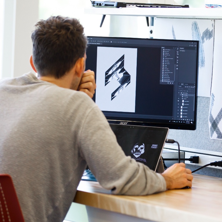 Student sitting at a desk and working on a computer.